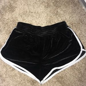 Black velvet shorts with white side stitching.